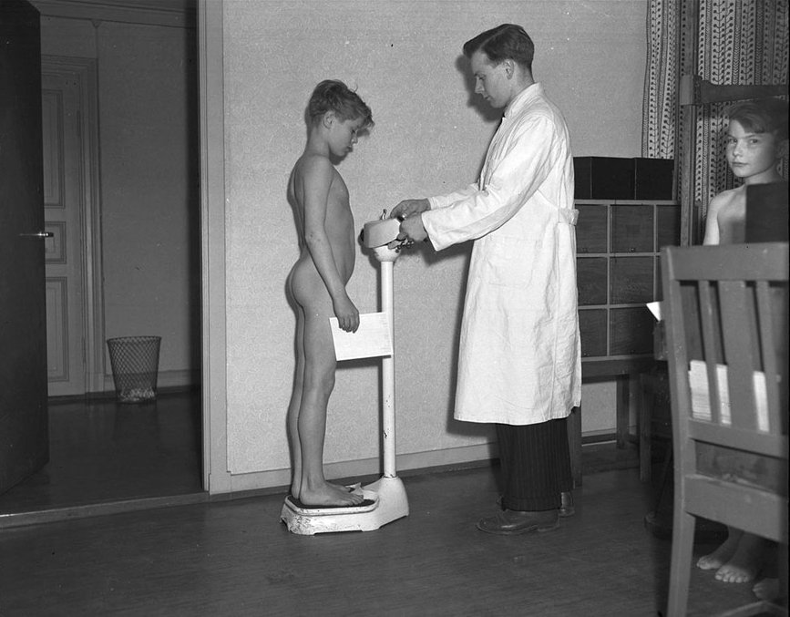 Кабинет врача норвежской спортивной конфедерации, медицинский осмотр мальчика, взвешивание. 17 марта 1949 года.
